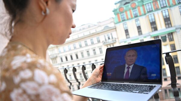 Девушка смотрит трансляцию прямой линии с президентом РФ Владимиром Путиным