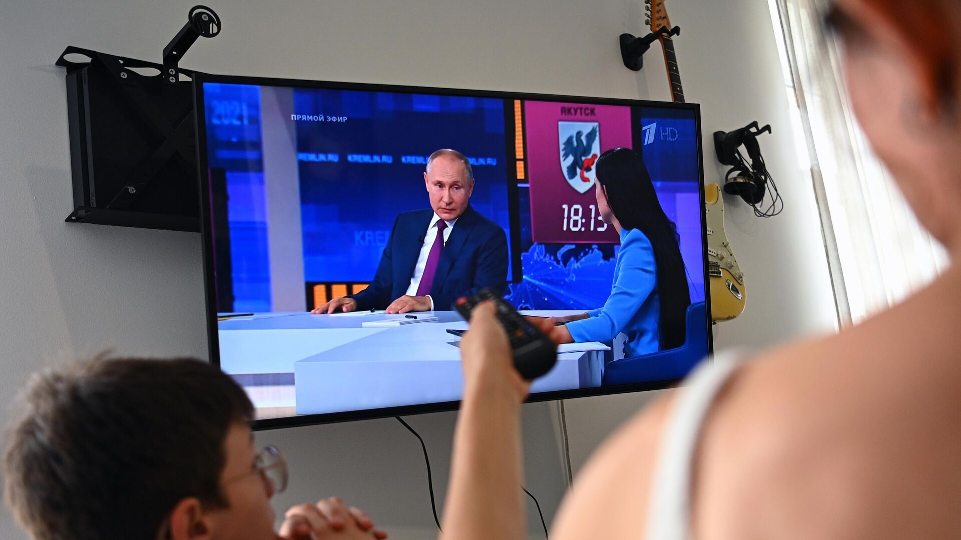 Женщина с ребенком смотрят трансляцию прямой линии с президентом РФ Владимиром Путиным - РИА Новости, 1920, 30.06.2021
