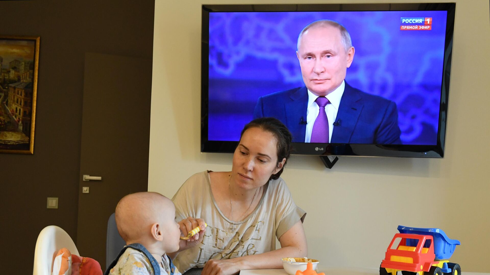 Женщина с ребенком смотрят трансляцию прямой линии с президентом РФ Владимиром Путиным - РИА Новости, 1920, 01.02.2022