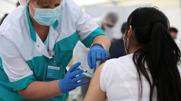 Медицинский работник во время вакцинация мигрантов от COVID-19 российским препаратом Спутник Лайт на территории ТЦ Садовод в Москве