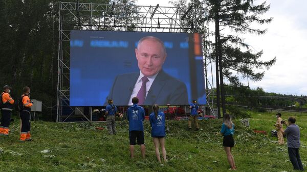 Люди смотрят трансляцию прямой линии с президентом РФ Владимиром Путиным в фанпарке Бобровый лог в Красноярске