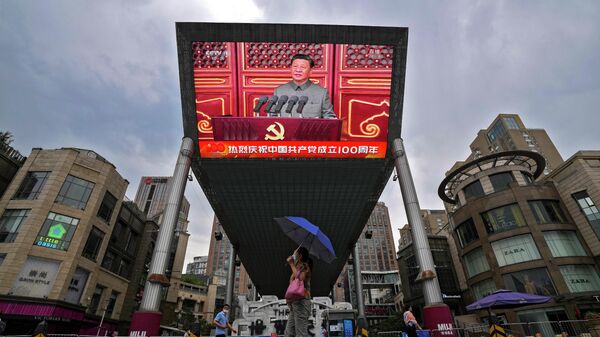 Трансляция выступления председателя КНР Си Цзиньпина на площади Тяньаньмэнь во время мероприятия, посвященного 100-летию Коммунистической партии Китая, на экране на здании торгового центра