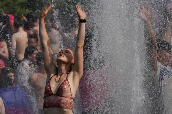 Люди купаются в фонтане Вашингтон-Сквер-парка в Нью-Йорке