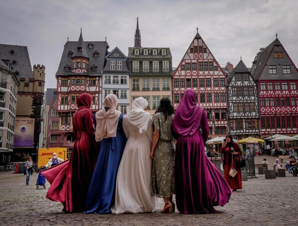 Невеста и ее друзья позируют для фотографий после свадьбы на площади Рёмерберг во Франкфурте, Германия