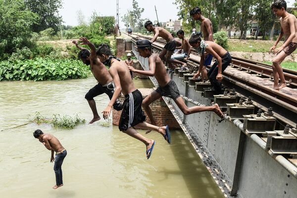 Юноши прыгают в канал на окраине Амритсара