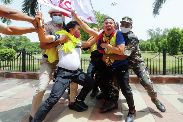 Полицейские задерживают демонстрантов во время акции протеста против празднования 100-летия Коммунистической партии Китая у посольства Китая в Нью-Дели, Индия