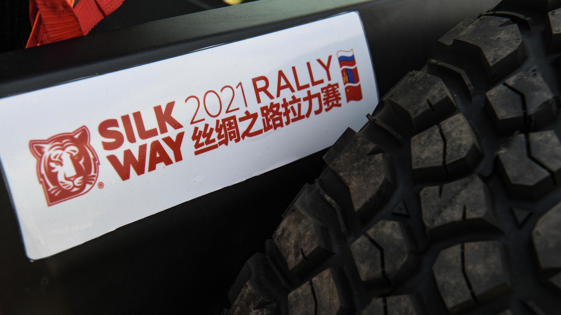 Наклейка с фирменной символикой на одном из автомобилей участников перед началом международного ралли Шелковый путь - 2021 в Омске. - РИА Новости, 1920, 01.07.2021