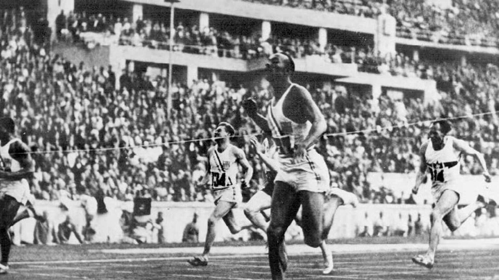 Американский атлет Джесси Оуэнс пересекает финишную черту в забеге на 100 метров на Олимпиаде 1936 года в Берлине - РИА Новости, 1920, 04.07.2021
