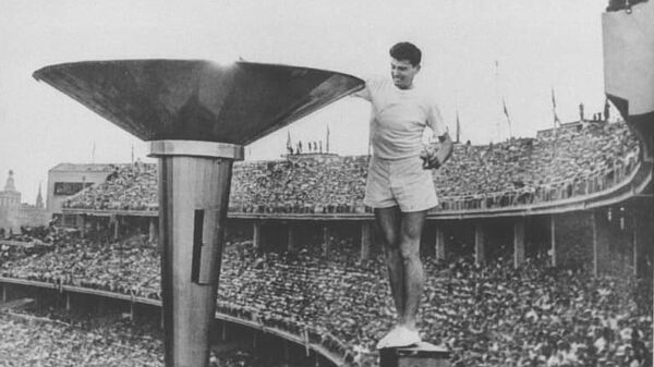 Австралийский легкоатлет Рон Кларк зажигает Олимпийский огонь перед началом Игр 1956 года в Мельбурне
