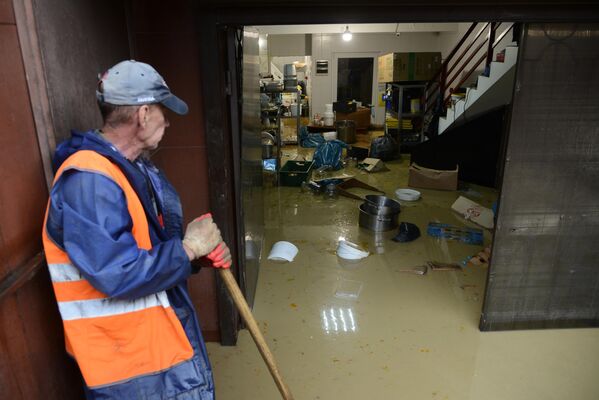 Сотрудник коммунальной службы устраняет последствия подтопления магазина в микрорайоне Кудепста Хостинского района Сочи