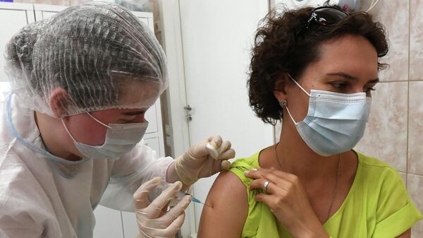 Медицинский работник и посетитель во время вакцинации против COVID-19 в Красноярске