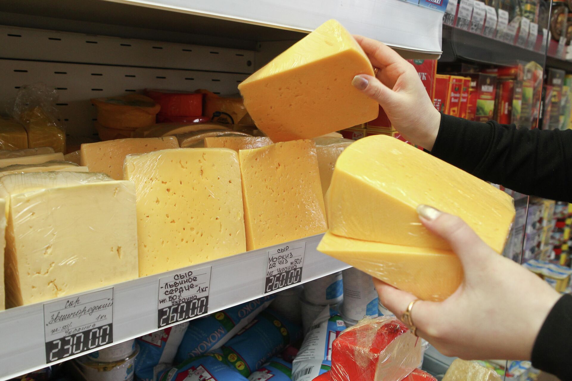 Продавец раскладывает фасованный сыр производства Украины на прилавке продуктового магазина Томска - РИА Новости, 1920, 05.07.2021