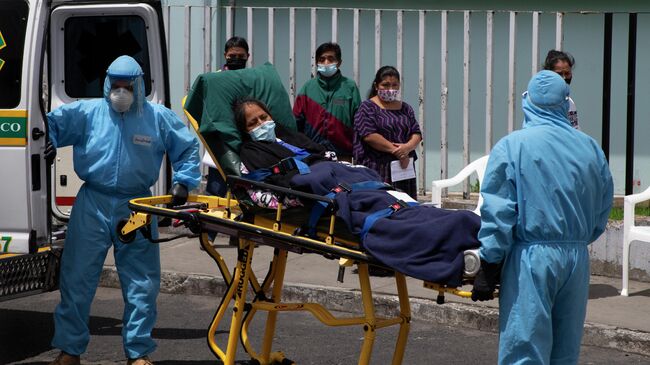 Медицинские работники и пациент с коронавирусной инфекцией возле больницы в Гватемале 