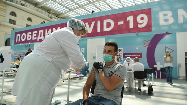 Посетитель и медицинский сотрудник в центре вакцинации от COVID-19 в Гостином дворе в Москве