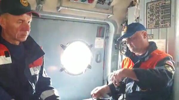 Сотрудники спасательной службы МЧС РФ на борту вертолета Ми-8МТВ-1 во время поисков самолета Ан-26 на Камчатке. Стоп-кадр  видео 