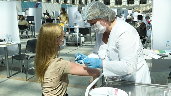 Медицинский сотрудник делает посетителю прививку