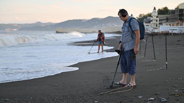 Люди с металлоискателями на пляже Ривьера в Сочи после подтопления