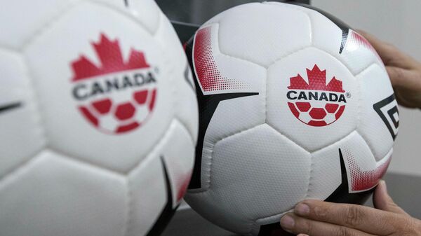 An employee adjusts balls at Soccer Canada Headquarters in Ottawa, Ontario on June 13, 2018, as Canada will co-host the 2026 World Cup with Mexico and the US. - The 2026 World Cup hosted by Canada, Mexico and the United States will be a great tournament, Canadian Prime Minister Justin Trudeau said Wednesday, setting aside a simmering trade dispute with Washington. Good news this morning: The 2026 FIFA World Cup is coming to Canada, the US and Mexico, the prime minister said in a Twitter message. Congratulations to everyone who worked hard on this bid –- it's going to be a great tournament! (Photo by Lars Hagberg / AFP)