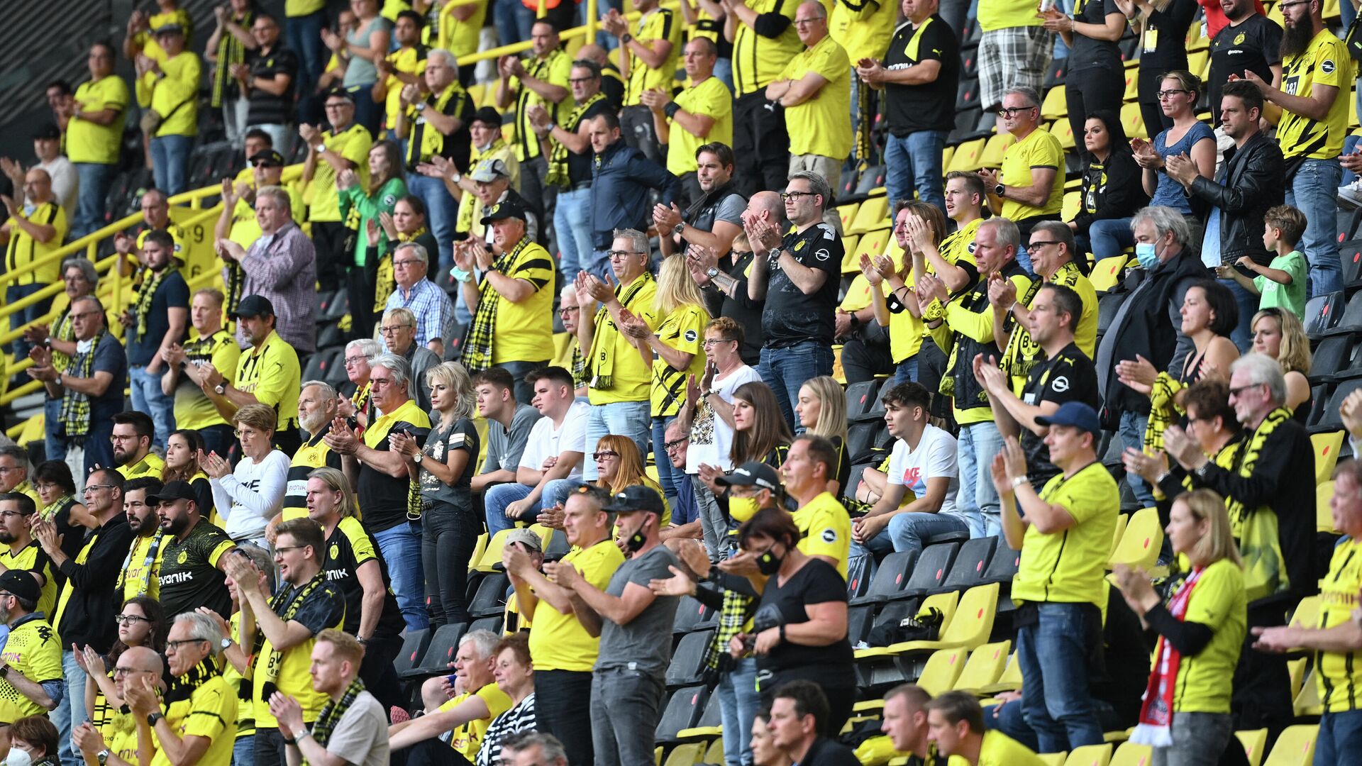 (FILES) In this file photo taken on September 19, 2020 Dortmund's fans applaud during the German first division Bundesliga football match Borussia Dortmund v Borussia Moenchengladbach in Dortmund, western Germany. - Bundesliga clubs and other German sports venues will be allowed to welcome up to 25,000 spectators from next month, the city of Berlin said July 6, 2021 after a meeting of officials from Germany's 16 states. (Photo by Ina Fassbender / AFP) - РИА Новости, 1920, 06.07.2021