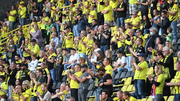 (FILES) In this file photo taken on September 19, 2020 Dortmund's fans applaud during the German first division Bundesliga football match Borussia Dortmund v Borussia Moenchengladbach in Dortmund, western Germany. - Bundesliga clubs and other German sports venues will be allowed to welcome up to 25,000 spectators from next month, the city of Berlin said July 6, 2021 after a meeting of officials from Germany's 16 states. (Photo by Ina Fassbender / AFP)