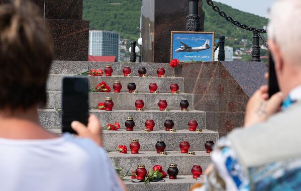 Люди возле стихийного мемориала на ступенях стелы Город воинской славы в центре Петропавловска-Камчатского