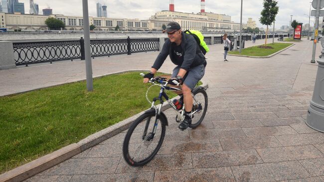 Мужчина катается на велосипеде на набережной Тараса Шевченко в Москве Мужчина катается на велосипеде на набережной Тараса Шевченко в Москве