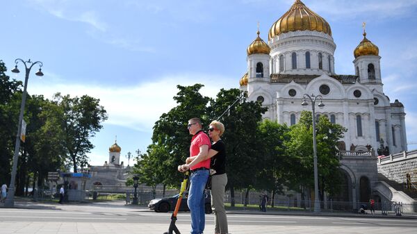 Люди катаются на самокате на Пречистенской набережной в Москве