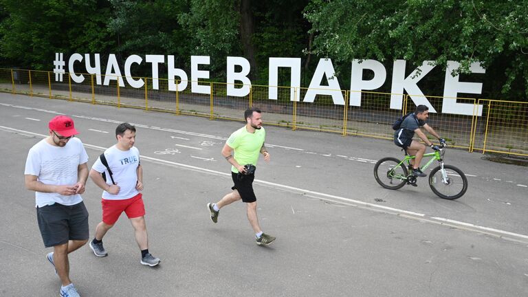 Люди возле арт-объекта Счастье в парке на Воробьевской набережной в Москве