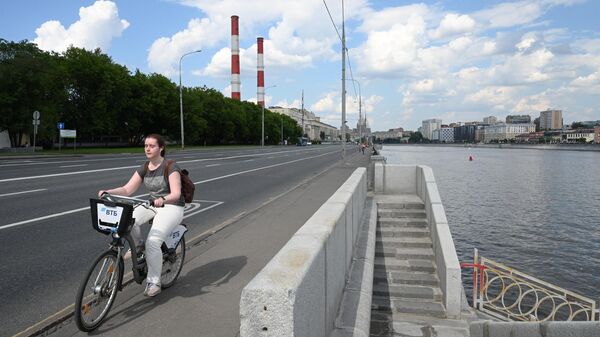 Девушка катается на велосипеде на Бережковской набережной в Москве