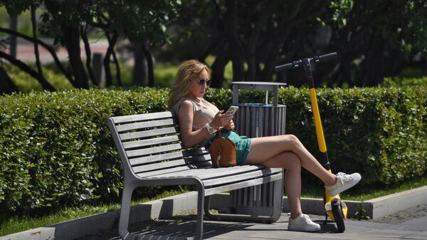 Девушка со смартфоном в парке