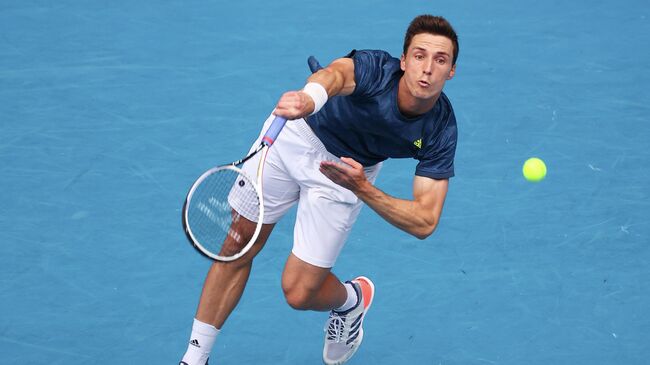 Britain's Joe Salisbury serves as he plays with partner Rajeev Ram of the US during their men's doubles final match against Croatia's Ivan Dodig and Slovakia's Filip Polasek on day fourteen of the Australian Open tennis tournament in Melbourne on February 21, 2021. (Photo by Patrick HAMILTON / AFP) / -- IMAGE RESTRICTED TO EDITORIAL USE - STRICTLY NO COMMERCIAL USE --