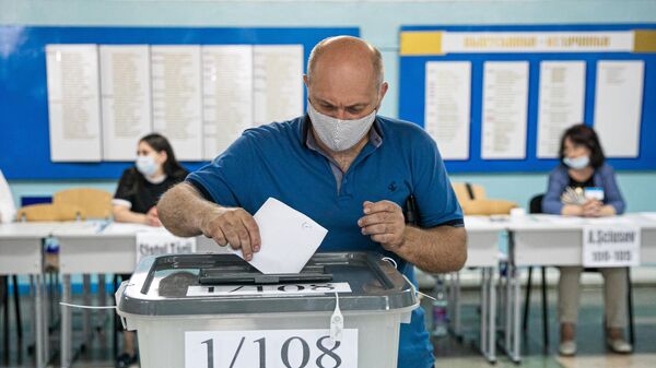 Мужчина голосует на избирательном участке в Кишиневе во время досрочных парламентских выборов в Молдавии