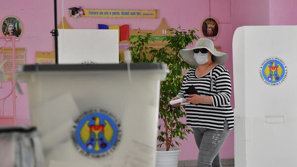 Женщина голосует на избирательном участке в Кишиневе во время досрочных парламентских выборов в Молдавии