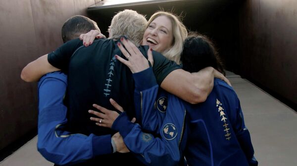 Главный астронавт-инструктор компании Virgin Galactic Бет Мозес обнимает Ричарда Брэнсона после завершения полета космического корабля VSS Unity