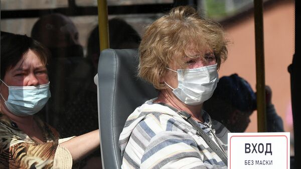 Пассажиры городского автобуса в защитных масках