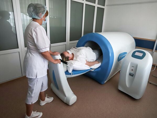 Женщина проходит лечебную процедуру в магнитотурботроне в рамках программы реабилитации после Covid-19 в санатории Родник в Пятигорске