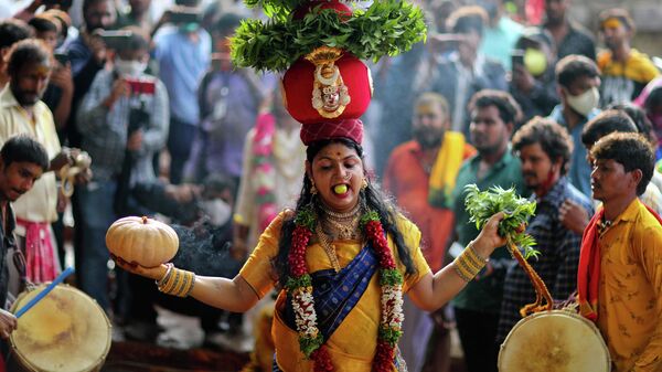 Люди приносят подношения богине Кали во время фестиваля Боналу в Хайдарабаде, Индия