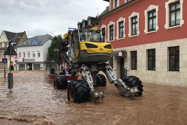 Автомобиль специального назначения везёт лодку в затопленном районе Эранг в Трире, западная Германия