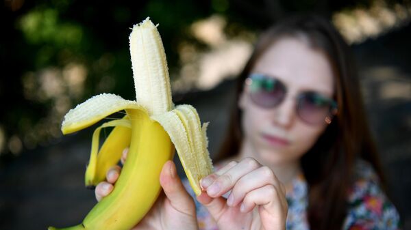 Девушка держит в руках банан 