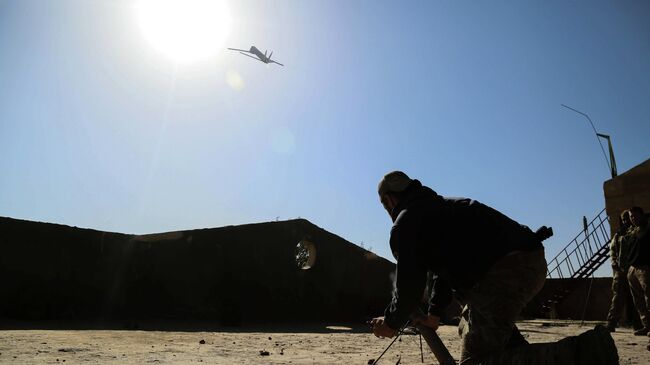 Американский военный запускает беспилотный летательный аппарат в Сирии