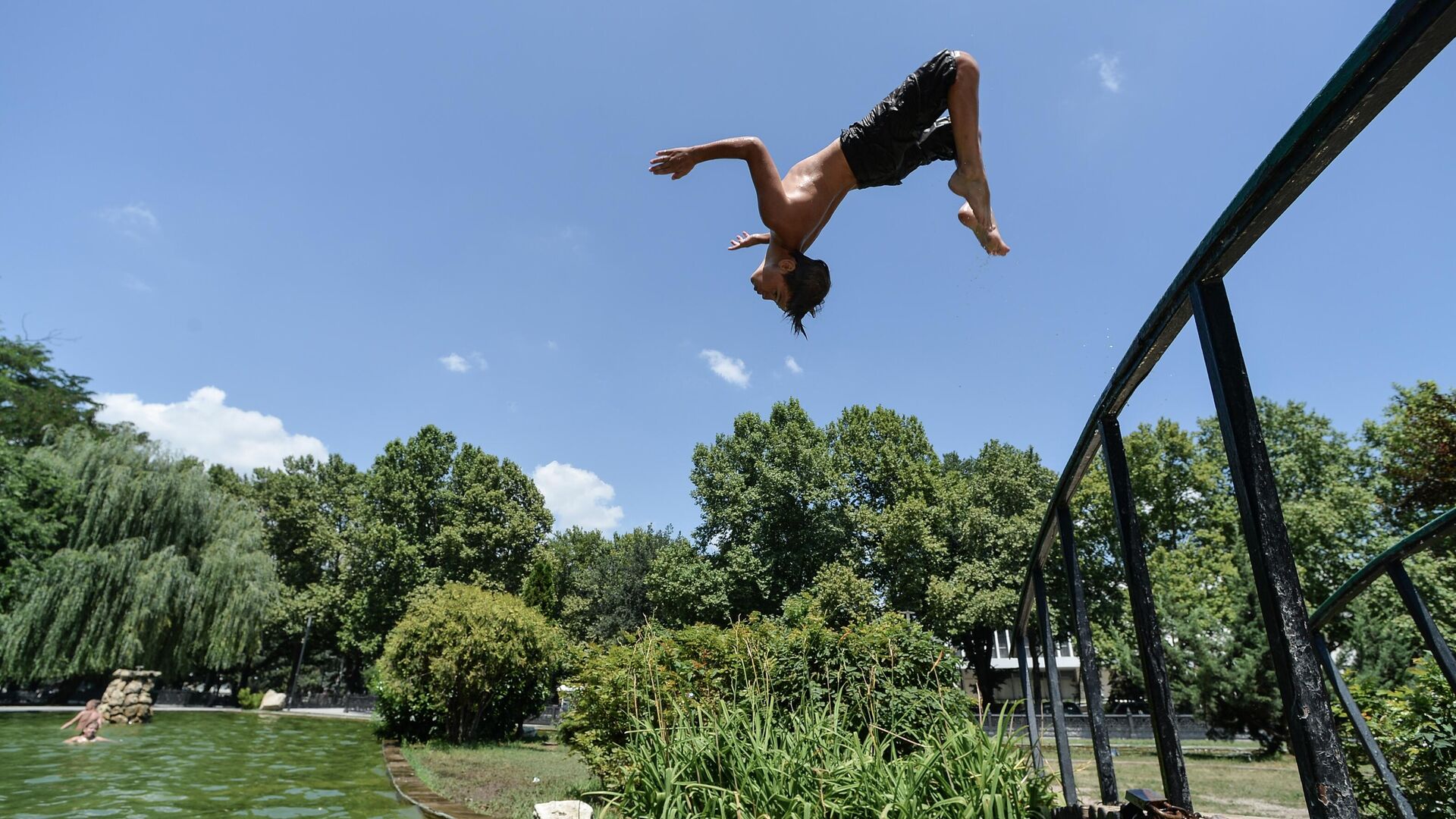 Мальчик прыгает в воду в жаркий день в Центральном парке культуры и отдыха Симферополя - РИА Новости, 1920, 23.06.2022