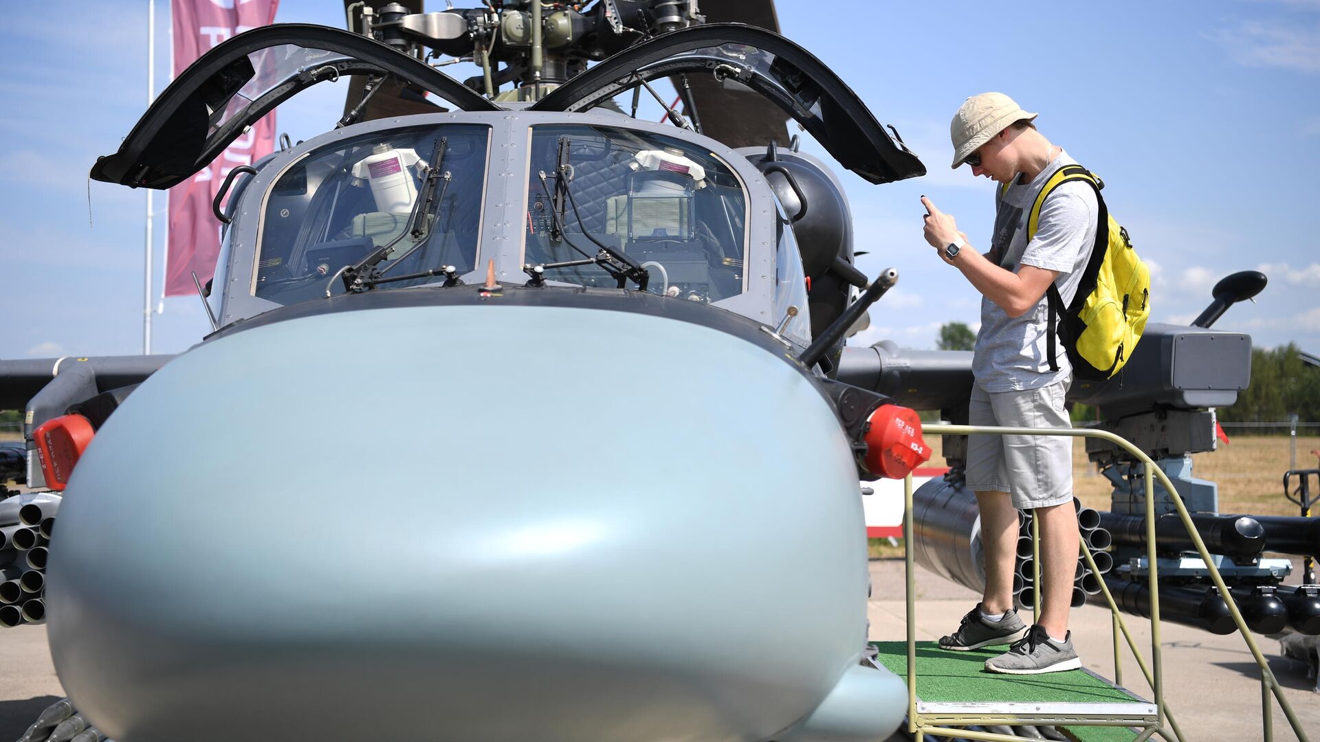 Посетитель фотографирует кабину российского разведывательно-ударного вертолета Ка-52 на Международном авиационно-космическом салоне МАКС-2021 - РИА Новости, 1920, 06.08.2021