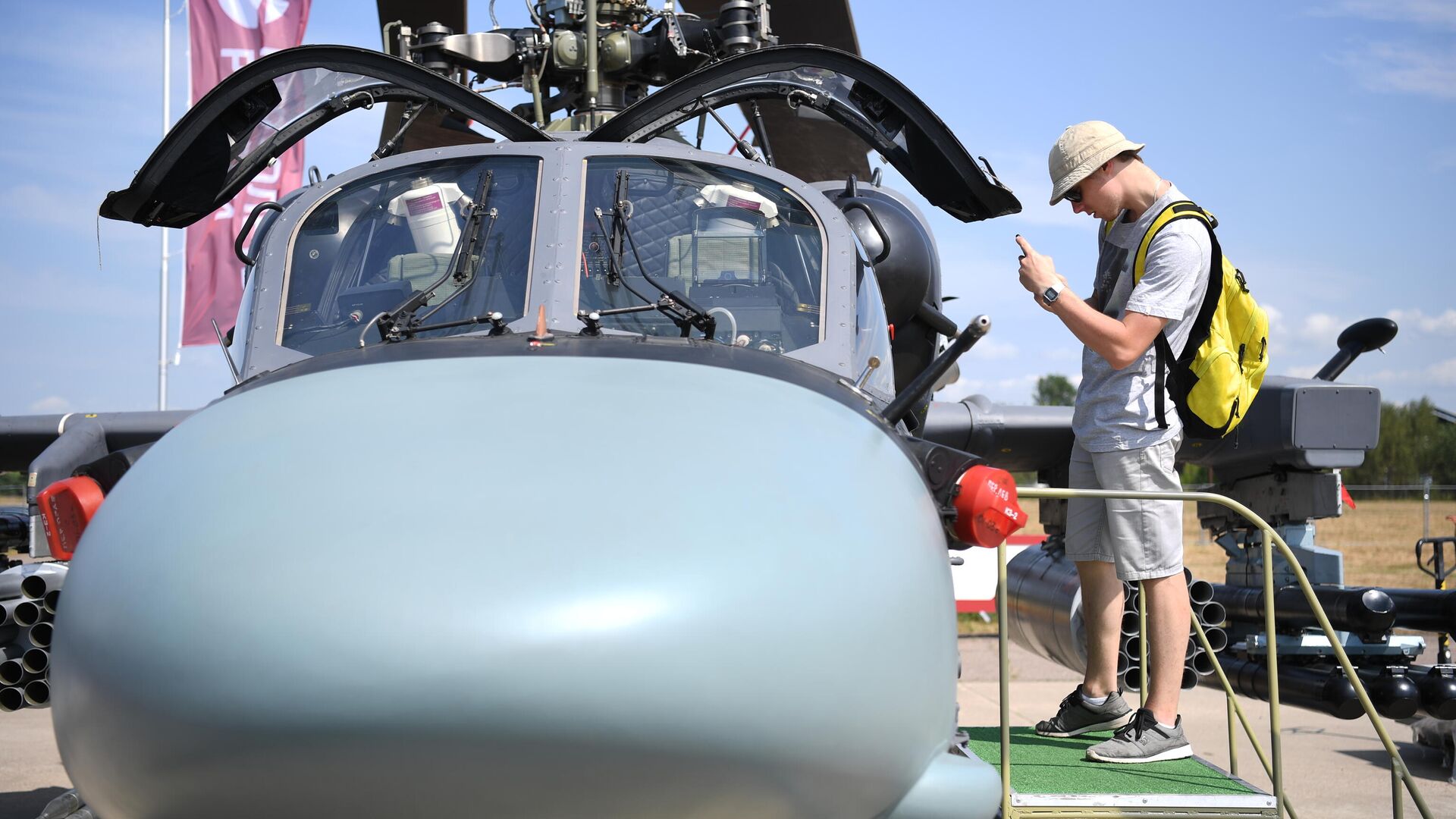 Посетитель фотографирует кабину российского разведывательно-ударного вертолета Ка-52 на Международном авиационно-космическом салоне МАКС-2021 - РИА Новости, 1920, 06.08.2021