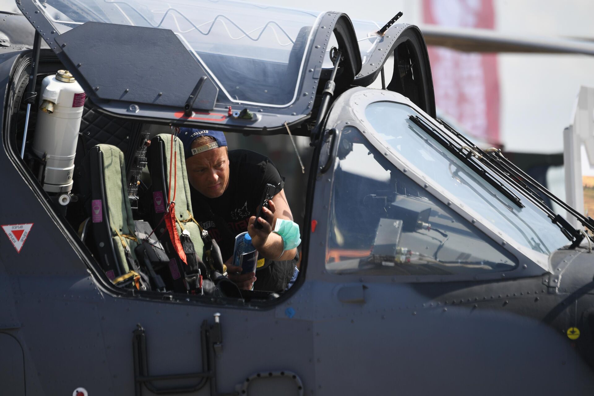 Посетитель фотографирует кабину российского разведывательно-ударного вертолёта Ка-52 на Международном авиационно-космическом салоне МАКС-2021 - РИА Новости, 1920, 20.07.2021