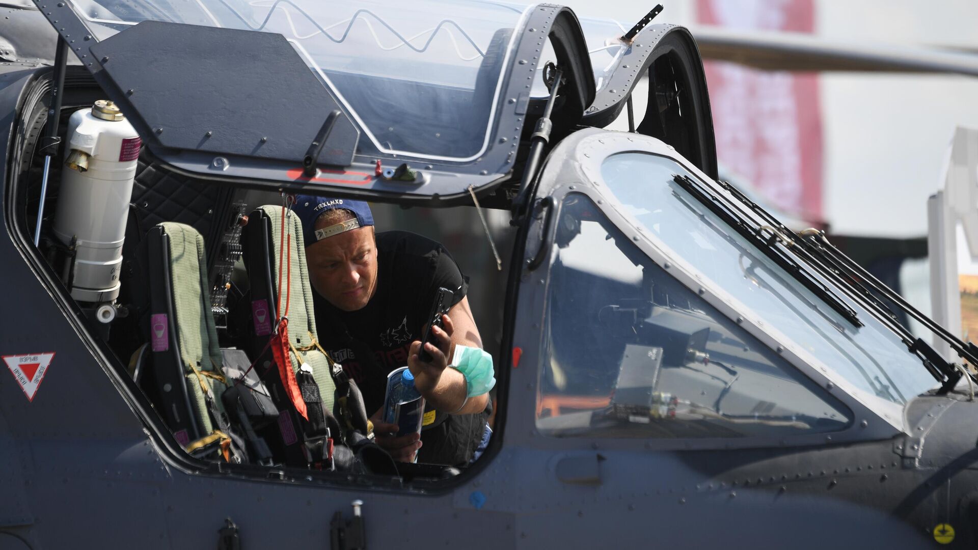 Посетитель фотографирует кабину российского разведывательно-ударного вертолёта Ка-52 на Международном авиационно-космическом салоне МАКС-2021 - РИА Новости, 1920, 25.08.2021
