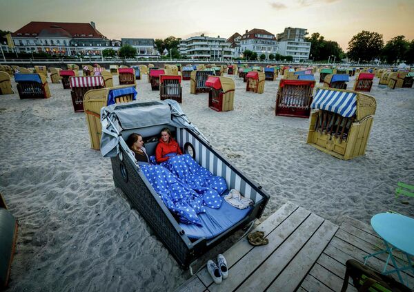 Девушки готовятся провести ночь в специально разработанном шезлонге на пляже Балтийского моря в Германии