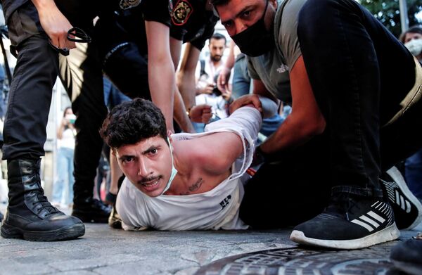 Стамбульская полиция задерживает активиста во время акции протеста в годовщину теракта в турецком Суруче в 2015 году