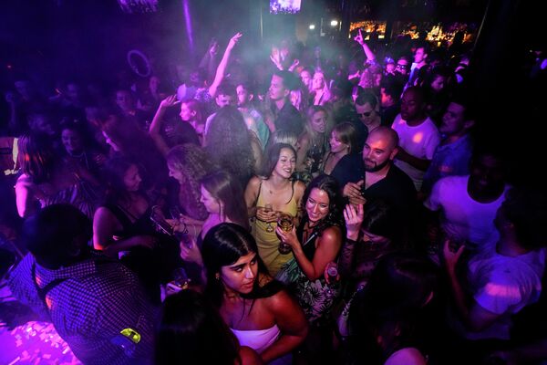Люди танцуют в баре после снятия ограничений в Лондоне
