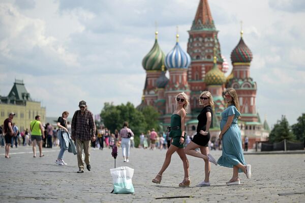 Девушки фотографируются на Красной площади у храма Василия Блаженного в Москве
