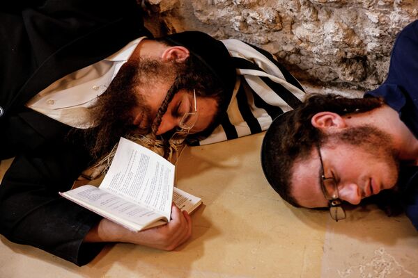 Еврейские верующие спят в национальный День траура 9 ава у Стены Плача в Иерусалиме